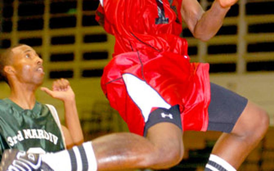 Robert Gibbons of Marine Corps Base Camp S.D. Butler drives to the basket past Adam Clement of 3rd Marine Division/Expeditionary Force during Saturday’s championship game at Camp Foster, Okinawa.