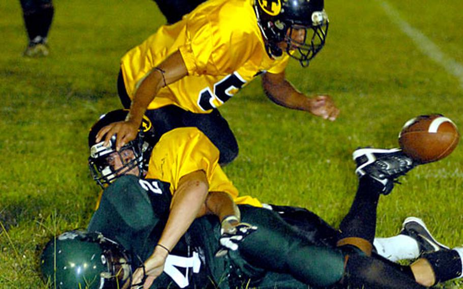 Chris Latham of the Kadena Panthers darts right to chase the ball after Kubasaki Dragons running back Tim Gardner is tackled by Kadena’s Sean Shattuck during Friday’s game at Camp Foster, Okinawa. Kadena beat Kubasaki 14-8.