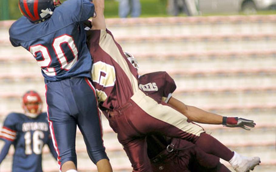 Aviano’s Andre Dean and two Baumholder defenders battle for a pass during the Saturday’s Division II playoff game at Baumholder.