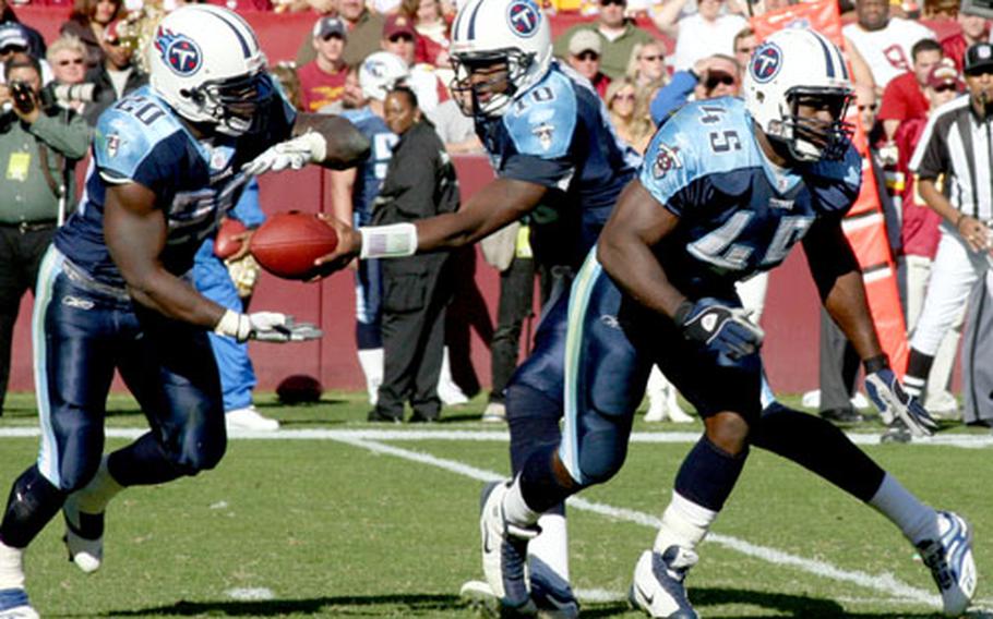 Ahmard Hall, right, blocks as Titans quarterback Vince Young hands off to running back Travis Henry.