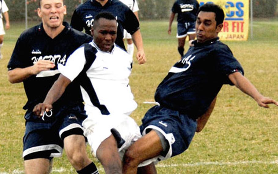 Phillip Sawyerr of Iwakuni gets sandwiched between defenders Dario Perez-Rincon and Rakesh Sundrum of U.S. Naval Hospital Camp Lester.