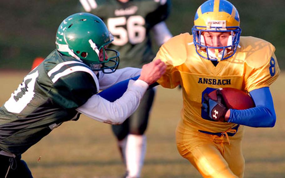 Ansbach’s Thomas Graham, right, keeps AFNORTH’s Chris Eden at bay as he rushes for a gain in Ansbach’s 34-6 victory in the DODDS-Europe Division III football championship.