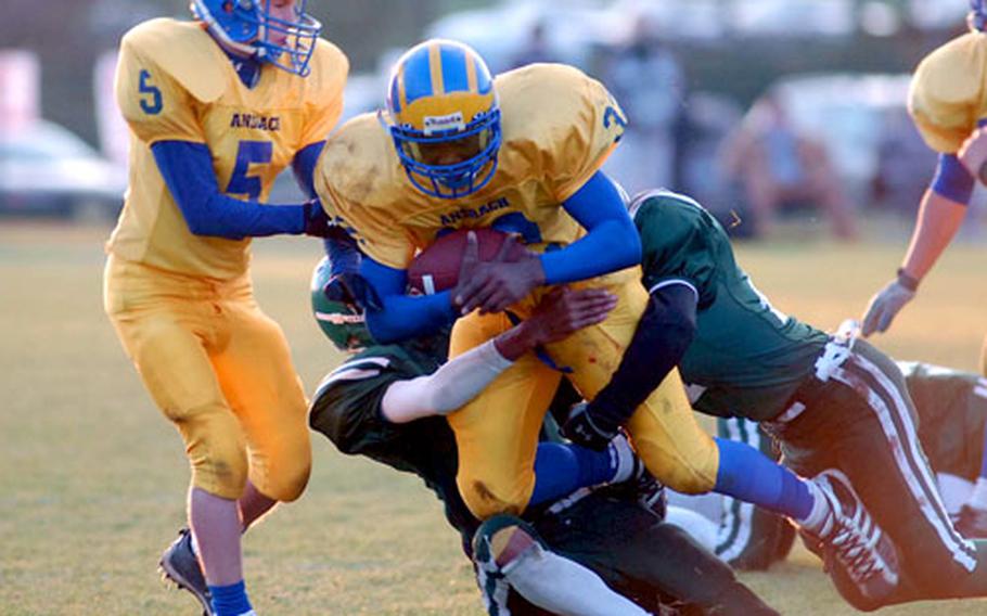 AFNORTH’s Anthony Poole and Brock Blankenship drag down Ansbach’s Xavier Sheppard in the Division III final in Baumholder. Ansbach won 34-6.