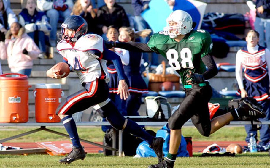 Bitburg’s Josh Collett outruns Naples’ Frank Wagner on an 80-yard touchdown run for the winning score in Bitburg’s 27-24 victory over the Naples Wildcats in the the DODDS-Europe Division II football title game.