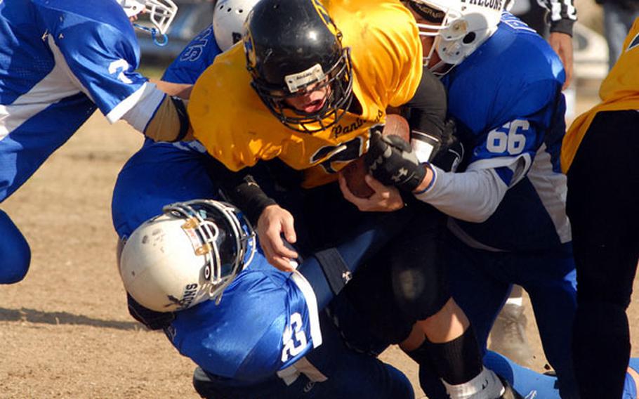 Kadena Panthers running back Sean Shattuck gets wrestled down by Seoul American defenders during Saturday’s Far East High School Class AA championship game at Yongsan Garrison, South Korea.