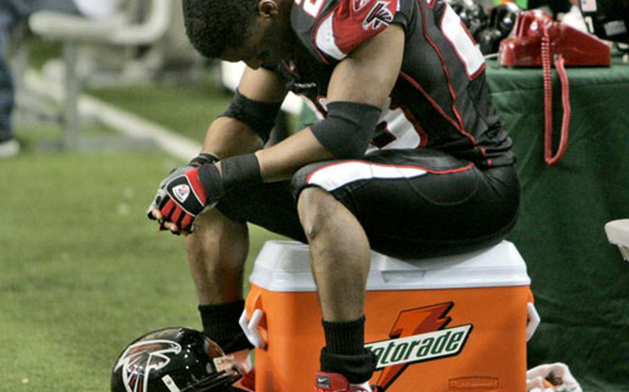 Atlanta Falcons’ Warrick Dunn sits on the sideline during the final seconds of the Falcons’ 31-13 loss to the New Orleans Saints on Sunday in Atlanta.