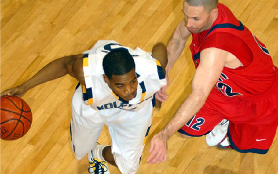 Guard Shawn Gross of Kunsan Air Base dribbles past guard Matt Wireman of the host Osan Defenders during Monday&#39;s double-elimination playoffs in the Pacificwide Open Holiday Basketball Tournament at Osan Fitness & Sports Complex, Osan Air Base, South Korea. The Defenders beat the Wolf Pack 89-58.