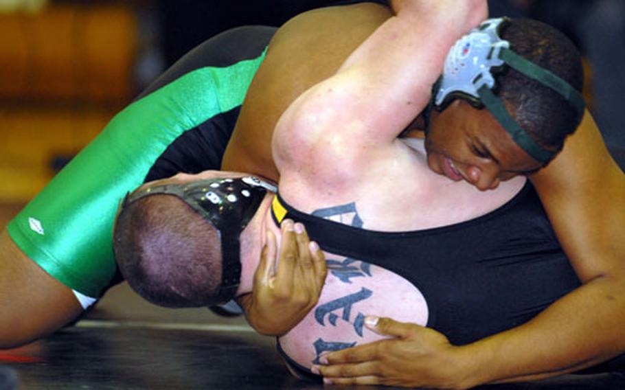 Kubasaki 215-pounder Lawrence McCain wrenches the shoulders of Kadena&#39;s Mike Ward to the mat during Thursday&#39;s Okinawa Activities Council season-opening dual meet at the Panther Pit, Kadena High School, Kadena Air Base, Okinawa. McCain pinned Ward in 1 minute, 20 seconds and the Dragons snapped a nine-meet losing streak to the Panthers, beating Kadena 39-20.