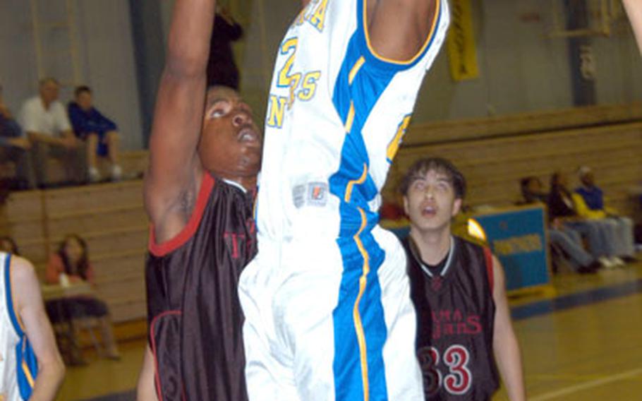 Zama American Trojans center Quincy Howard, left, defends against center Caiveon Thomas of the Yokota Panthers as the Trojans' Sean Wise (33) looks on during the first quarter of their DODDS-Japan Basketball League and Kanto Plain Association of Secondary Schools boys basketball game Friday night.