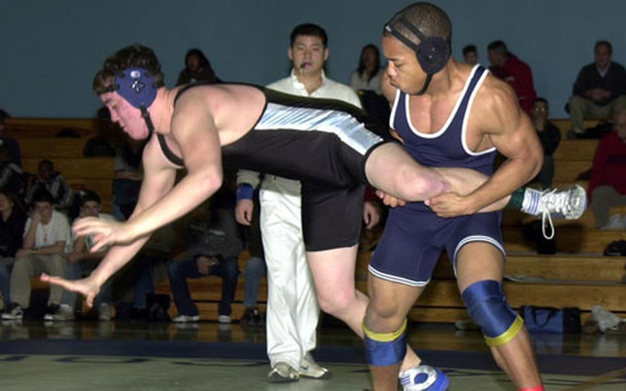 Seoul American Falcons 180-pounder Justin Stokes throws Daniel Burke of the Osan American Cougars during Saturday&#39;s Department of Defense Dependents Schools-Korea wrestling tri-meet at Falcon Gym, Seoul American High School, South Post, Yongsan Garrison, South Korea. Stokes won by technical fall 2-0 (7-0, 4-0).