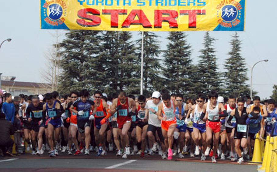 Runners take off through the starting gate at the 26th annual Frostbite Half Marathon at Yokota Air Base. Over 7,000 runners participated in the event.