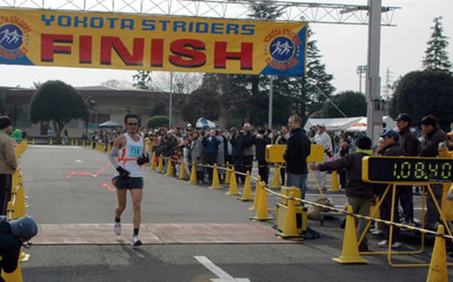 Runners take off through the starting gate the 26th annual Frostbite Half Marathon at Yokota Air Base. Over 7,000 runners participated in the event.