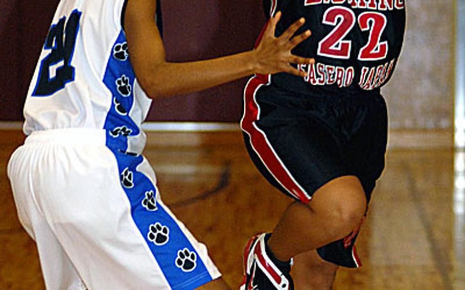 Kristia Suriben (22) of the E.J. King Cobras looks to pass as Destiny Sanders (21) of the Yokota Panthers defends during Saturday's DODDS-Japan Basketball League girls high school game at Samurai Gym, Matthew C. Perry High School, Iwakuni Marine Corps Air Station, Japan. E.J. King won 48-43 and improved to a league-best 10-1 and 21-1 overall.