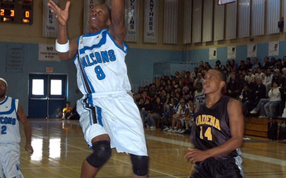 Seoul American High School’s Tyras Milner soars away from Kadena High School’s Terrone Sheffey to score during a tournament game at Seoul American High School, Friday. Seoul American High School won 84-65.