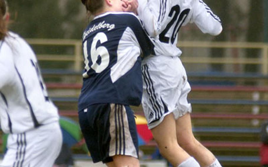 Jamie Cachuela, a freshman at Ramstein High School, heads a ball over Heidelberg’s Ana Anger during the second half of play Saturday at Ramstein. Anger scored Heidelberg’s only goal in a 4-1 loss.