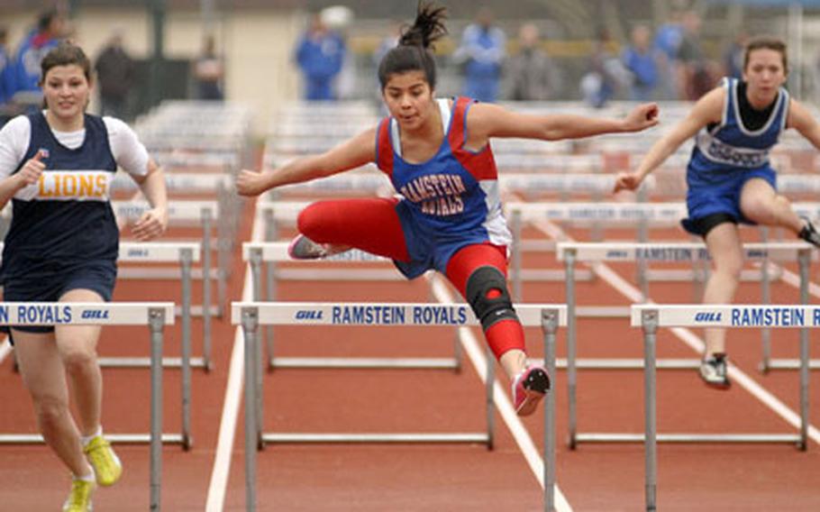 Amanda Garza, a junior from Ramstein High School, soars over the final hurdle during a track meet at Ramstein Saturday. Garza won the 100-meter girls high hurdles with a time of 17.9 Seconds.