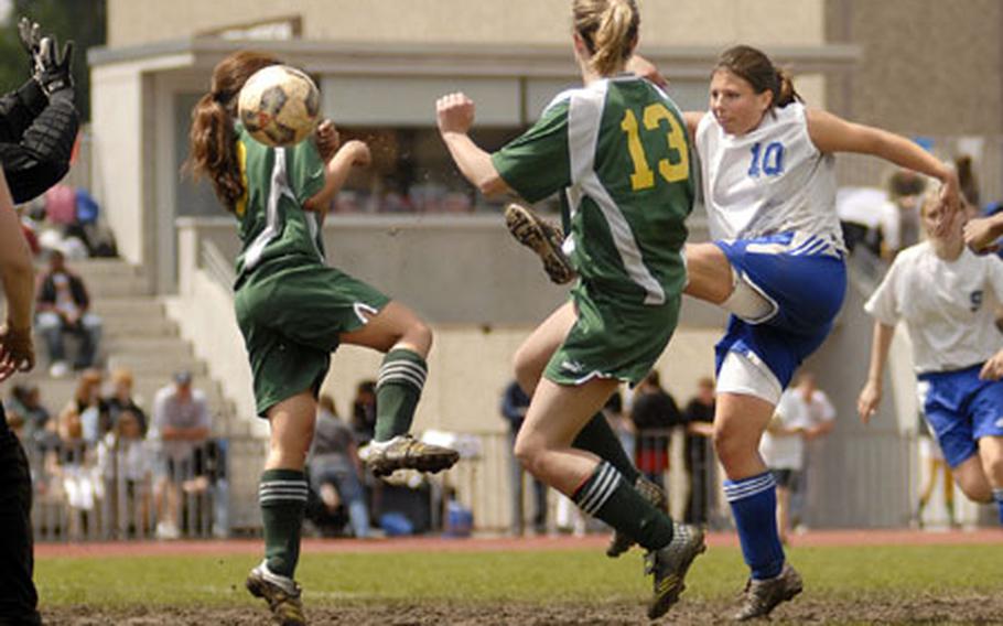 Lizz McVicker, 10, a junior from Brussels High School, fires the ball between Alconbury&#39;s Jelliz Calata and Brooke Bagnall during the title game of the DODDS-Europe girls Division IV soccer tournament. Brussels beat Alconbury 5-1 for its second-straight D-IV crown. McVicker, who scored three times in the game, was named the tournament MVP.