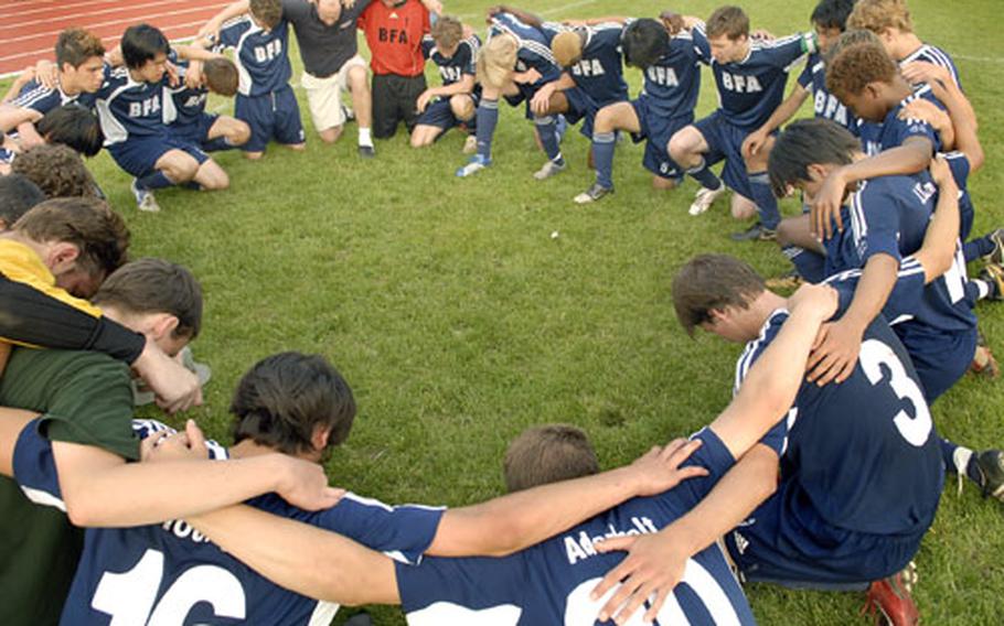 Billy Reed, top right, the team captain of Black Forest Academy, leads his team in prayer after clinching the Div. II DoDDS Europe Soccer Championship title Saturday evening at Ramstein. Reed was named tournament MVP.
