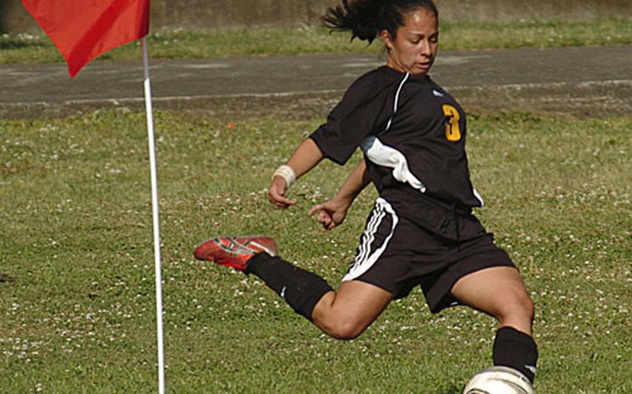 Jen Abel from Kadena High School takes a side kick to try to score against Yokota on Monday in the Far East Girls Soccer Tournament on Yokota Air Base, Japan. Kadena beat Yokota 3-0.