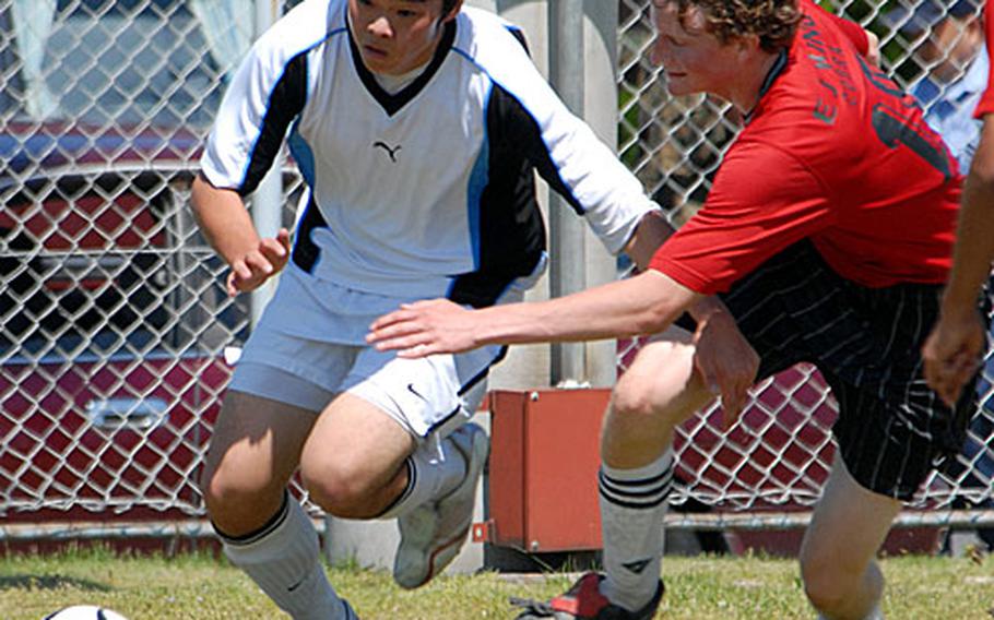 Cougars striker Thomas Chung and Cobras midfielder Leif Bogen chase the ball.