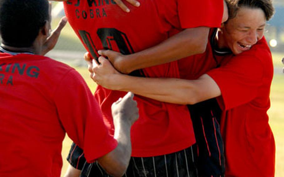 E.J. King senior Jose Lopez Jr. is embraced by teammates after he scored the final shootout goal.