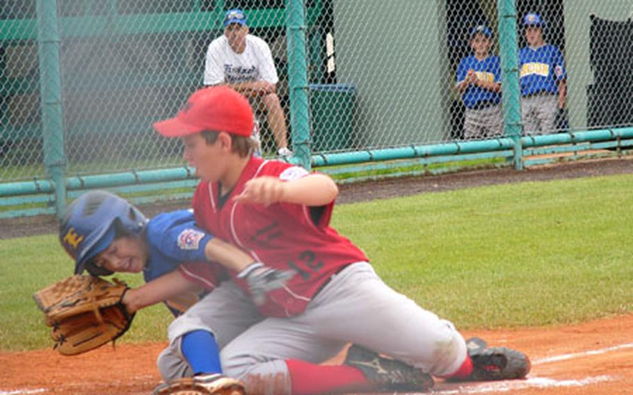 Stuttgart-Wiesbaden relief pitcher Joseph "Fish" Patrick can&#39;t keep London&#39;s Clay Dudek from scoring on a wild pitch during the England champions&#39; six-run sixth inning Saturday in a semifinal game of Little League Baseball&#39;s Transatlantic Regional at Kutno, Poland. London won 9-6.