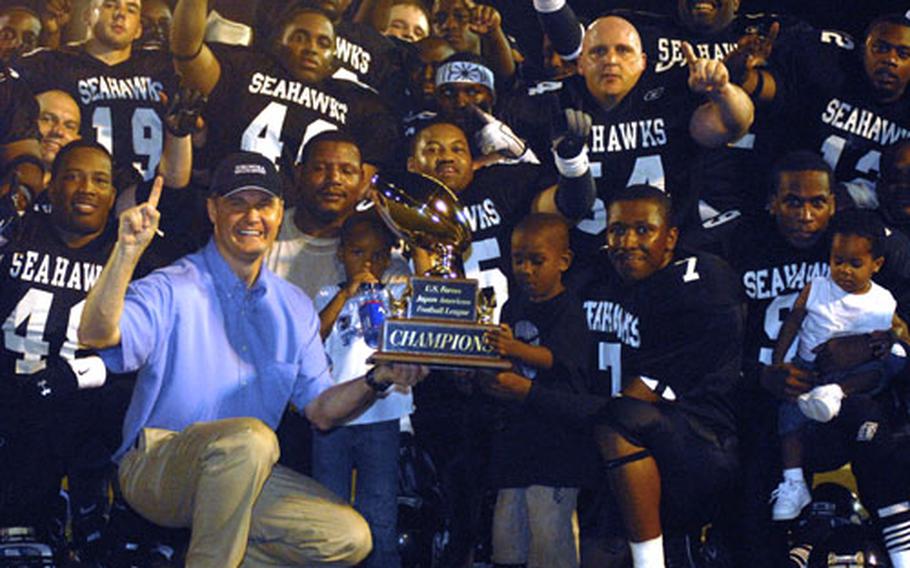 Fleet Activities Yokosuka commanding officer Capt. Daniel L. Weed and the Yokosuka Seahawks celebrate the U.S. Forces Japan-American Football League championship.