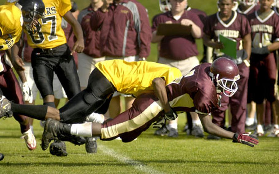 Diving for yards, Prince Owusu, a Baumholder freshman, is brought down by Vicenzad sophomore Napolian Myhand Saturday during the first quarter at Baumholder. After an impressive first half of rushing, Owusu moved to quarterback early in the second half after starter LaCross Gray left with an injury.