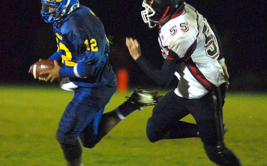 Ansbach quarterback John Willis escapes the grasp of Bitburg&#39;s Rob Ferguson in second-half action in the Division II final. After a half tied at 8-8, Willis lead the Cougars to a 44-8 win.