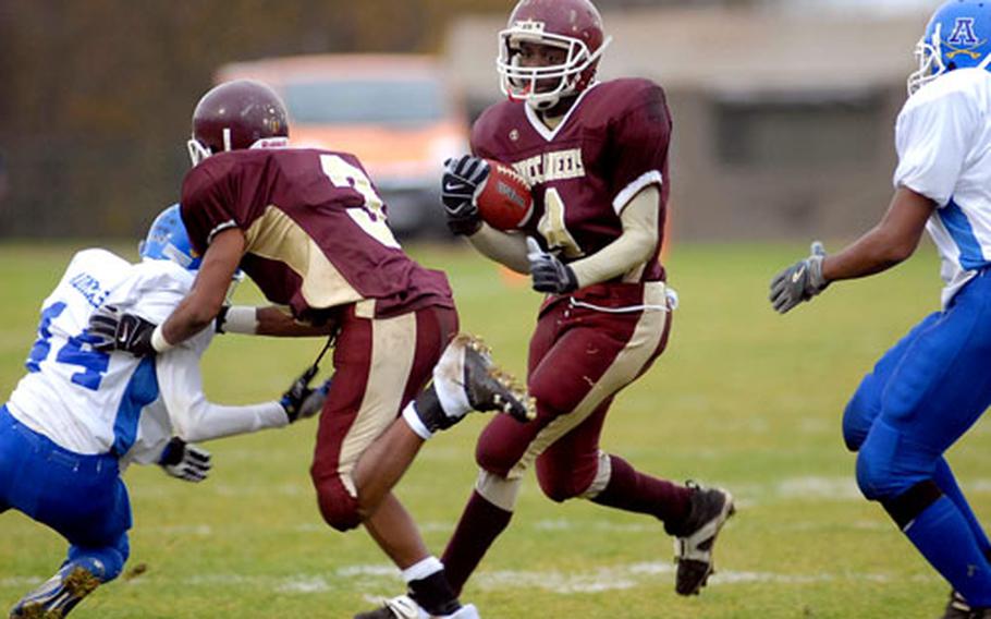 Baumholder&#39;s Artrell Davis gets a good block from teammate Fred Styles on Rota&#39;s Keita Silk, as he rushes for a gain. Baumholder took the Division III title with a 14-0 win.