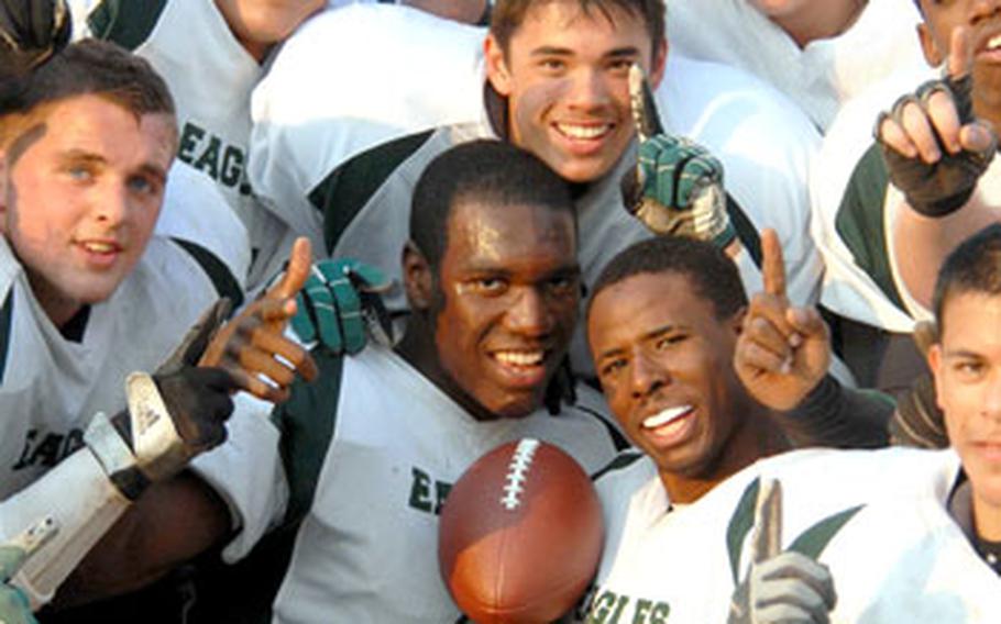 Robert D. Edgren Eagles football players celebrate &#39;round the trophy after Saturday&#39;s Far East High School Class A football championship game.