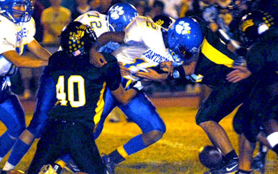 The football pops loose from the hands of Yokota quarterback DeEric Harvin (12) during Saturday&#39;s Far East High School Class AA football championship game. Kadena rallied from a 13-7 halftime deficit to beat Yokota 38-13 for the school&#39;s first Class AA title.