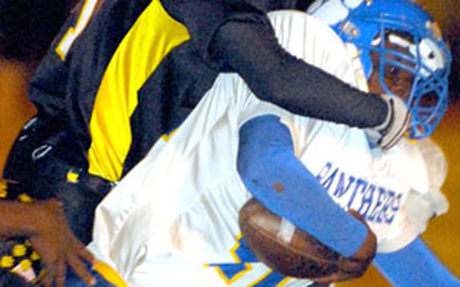 Shun Bowens of Kadena wrestles Yokota running back Anthony McNeill to the ground