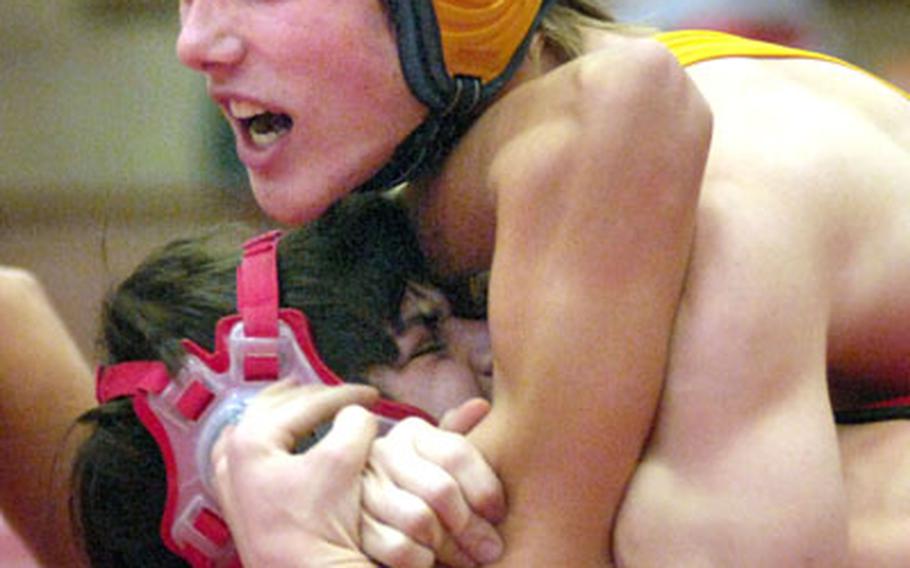 Michael Spencer of Wiesbaden puts the squeeze on Kaiserslautern’s Briton Rapier Saturday at the Kaiserslautern High School gym. Spencer went on to defeat Nik Yocum, a senior from Kaiserslautern, in the 140 pound finals 14-11. Spencer pinned Rapier in the 2nd round of their match-up.