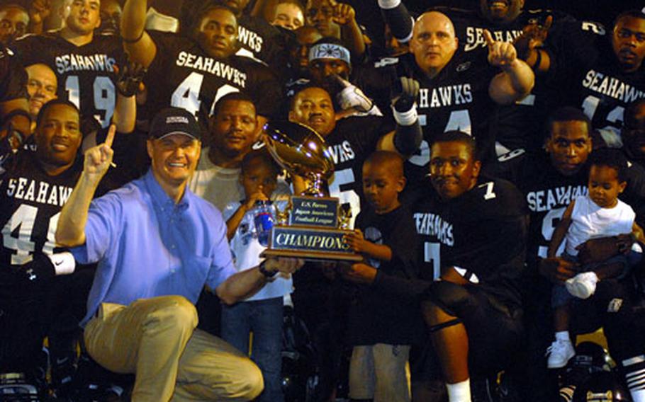 Fleet Activities Yokosuka commanding officer Capt. Daniel L. Weed and the Yokosuka Seahawks celebrate the U.S. Forces Japan-American Football League championship after Saturday's Torii Bowl game at Berkey Field, Yokosuka Naval Base, Japan. The Seahawks won their seventh USFJ-AFL title in eight years, blanking Yokota 7-0 in the lowest-scoring league championship game in history.