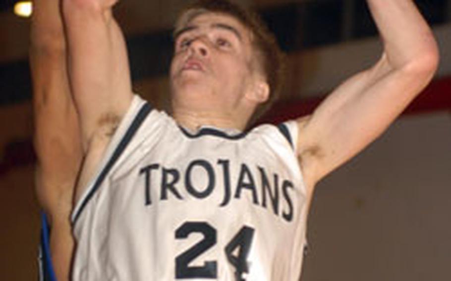 Zama American’s Nelson Bishop puts up a shot against Seoul American on Tuesday. He scored 16 points in the Trojans’ OT win.