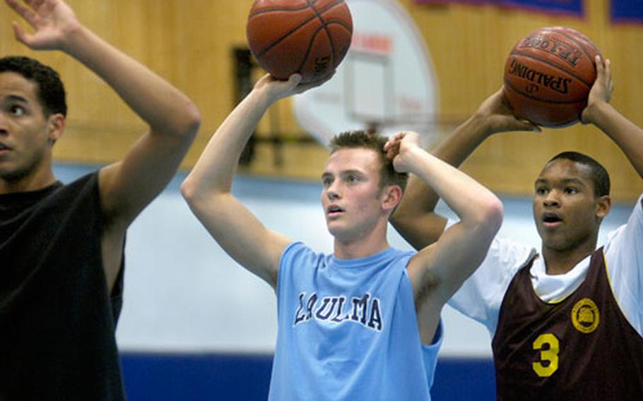 Ramstein senior Scott Sublousky, 18, center, sets up for a drill during practice with teammates Michael Wallace, right, and Brice Relaford on Jan. 17 at Ramstein. Sublousky wears a shirt wth the word "laulima," an Hawaiian word that means “many hands working together.”