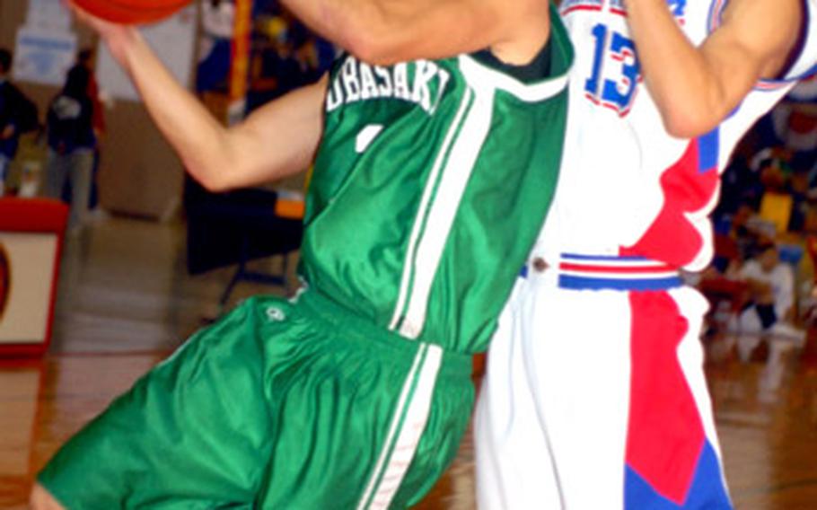 Kubasaki senior guard Michael Bennett is fouled on his way to the basket by Itoman guard Koji Kakazu during Saturday&#39;s playoff game in the Okinawa-American Shootout. Bennett and the Dragons beat the Raging Billows 86-54.