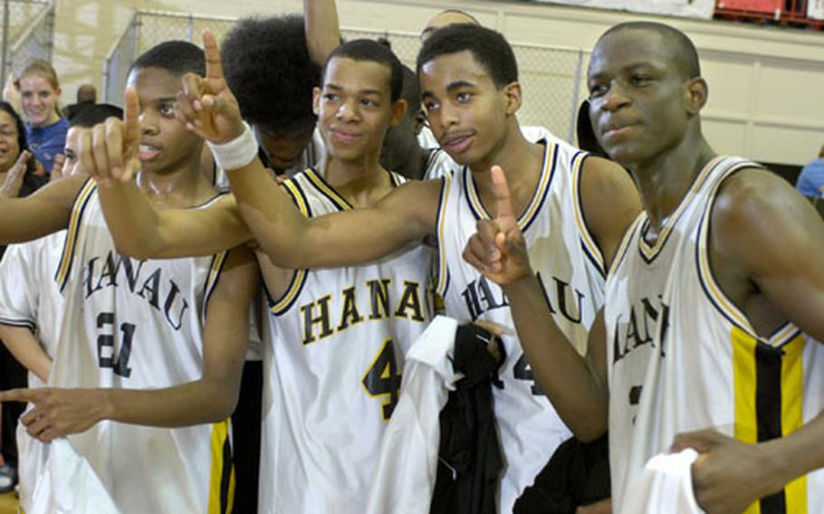 Spencer Miller, D’Shaun Carroll, Vernon Miles and Emanuel Moore, left to right, of Hanau High School, celebrate their Division IV boys basketball championship Friday night at the Mannheim sports arena.