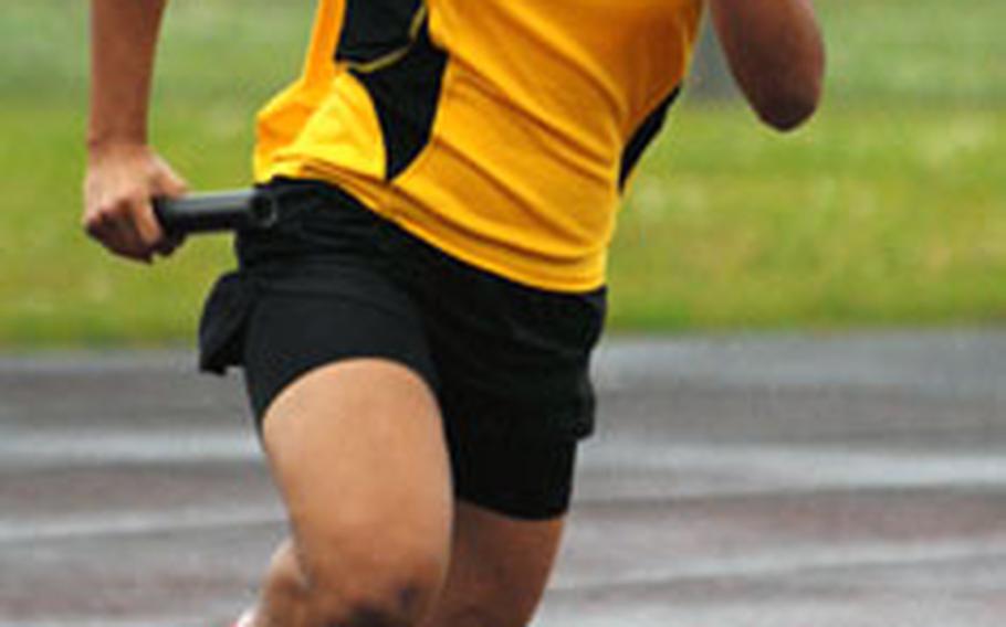 Kadena’s Lorien McKinney rounds the final turn in the 400-meter relay. Kadena won the event in 54.63 seconds.