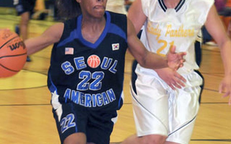 Seoul American’s Alyssa Gray (22) races downcourt with Kadena’s Monica Hayes (21) at her heels during Kadena’s 59-53 victory in the Class AA girls basketball final on Feb. 23. Hayes was chosen as the tournament MVP and Stars and Stripes female Athlete of the Quarter.