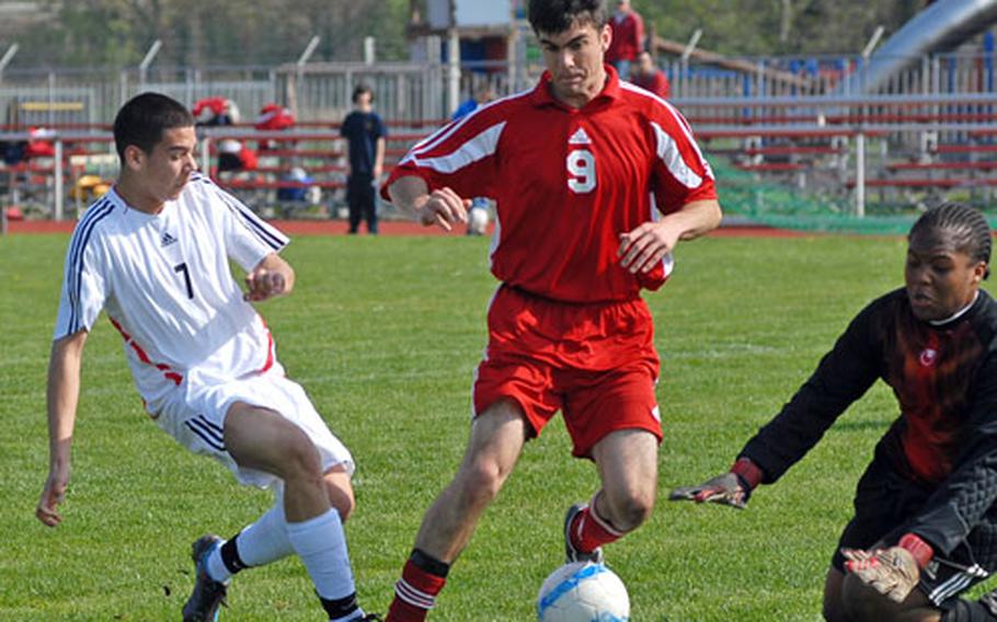 Kaiserslautern goalie James Green and teammate Mel McGregor stop Heidelberg&#39;s Carlos Villegas, left, in high school soccer action in Heidelberg, Germany, on Saturday.