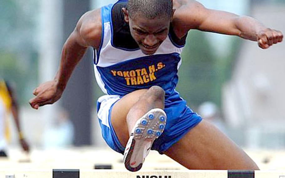 Phillip Williams of Yokota clears a hurdle in the 110-meter event. Williams edged out Kubasaki Dragons senior Randall O&#39;Bannon.