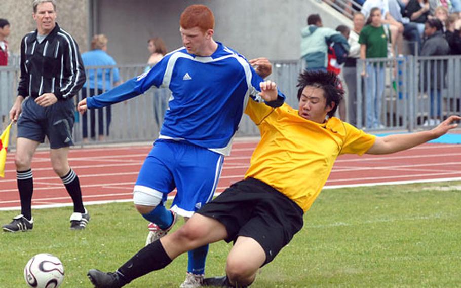 Alconbury&#39;s Yul McGrath edges the ball away from Rota&#39;s Travis Apling in a Division IV semifinal in Ramstein. Rota won 2-0 to reach Friday&#39;s championship game.