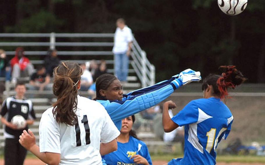 Hanau goalkeeper Jasmine Hawkins punches the ball away in front of Sigonella&#39;s Jenny Patron in a Division IV game that ended 0-0, at the DODDS-Europe soccer finals.