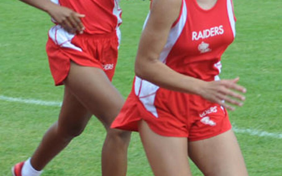 Kaiserslautern&#39;s Symone January passes the baton to Ruby Plummer to start the final leg of the girls 4x800 meter relay. The Kaiserslautern team won in 10 minutes, 15.45 seconds.