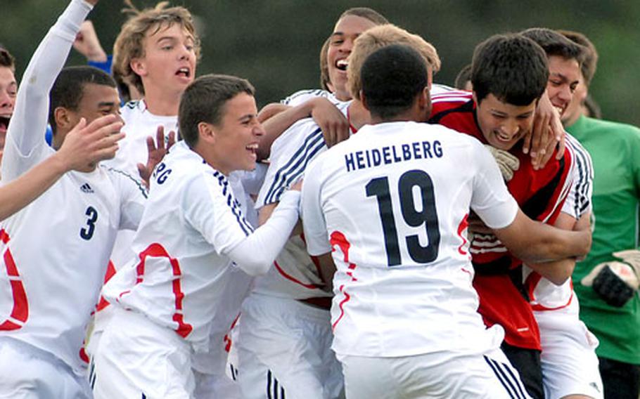 Heidelberg goalie Zach Herrington, in the red jersey, is stormed by his teammates after he stopped three Ramstein attempts in a shootout after the Division I boys final was tied 0-0 after regulation and overtime. Heidelberg won the shootout, 3-1.