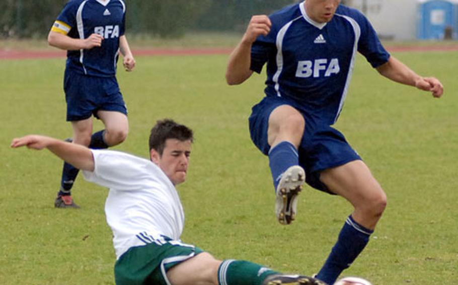 SHAPE&#39;s Javier Jimenez, left, clears the ball in front off Black Forest Academy&#39;s Judson Godbold in the Division II final at the DODDS-Europe soccer finals in Ramstein, Germany, Saturday night. BFA won the game 3-2 in overtime. Watching the action at left is Bruce Briggs.