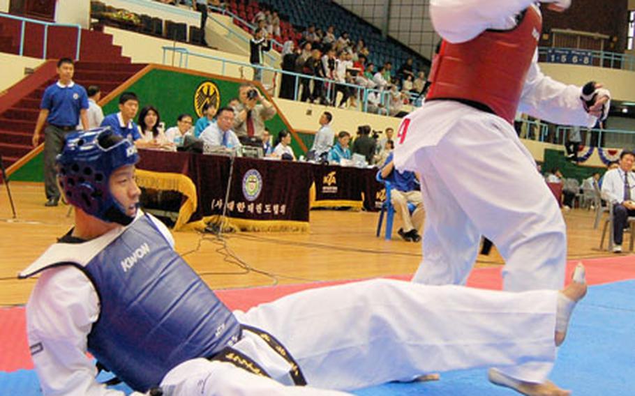 Heavyweight 2nd Lt. Steven Ostrander knocks his opponent South Korean Pvt. Park Kypung-houn to the mat Tuesday during the 18th Military World Tae Kwon Do Championship on Tuesday. Ostrander lost the match, 4-1.