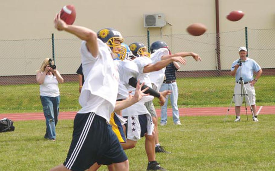 Quarterbacks attending the Kaiserslautern Youth Tackle Football Camp in Miesau, Germany, work on their releases Friday.